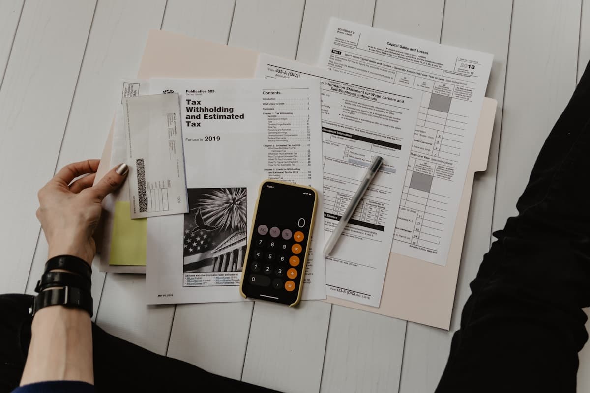 Tax forms, a pen and a phone calculator on a table